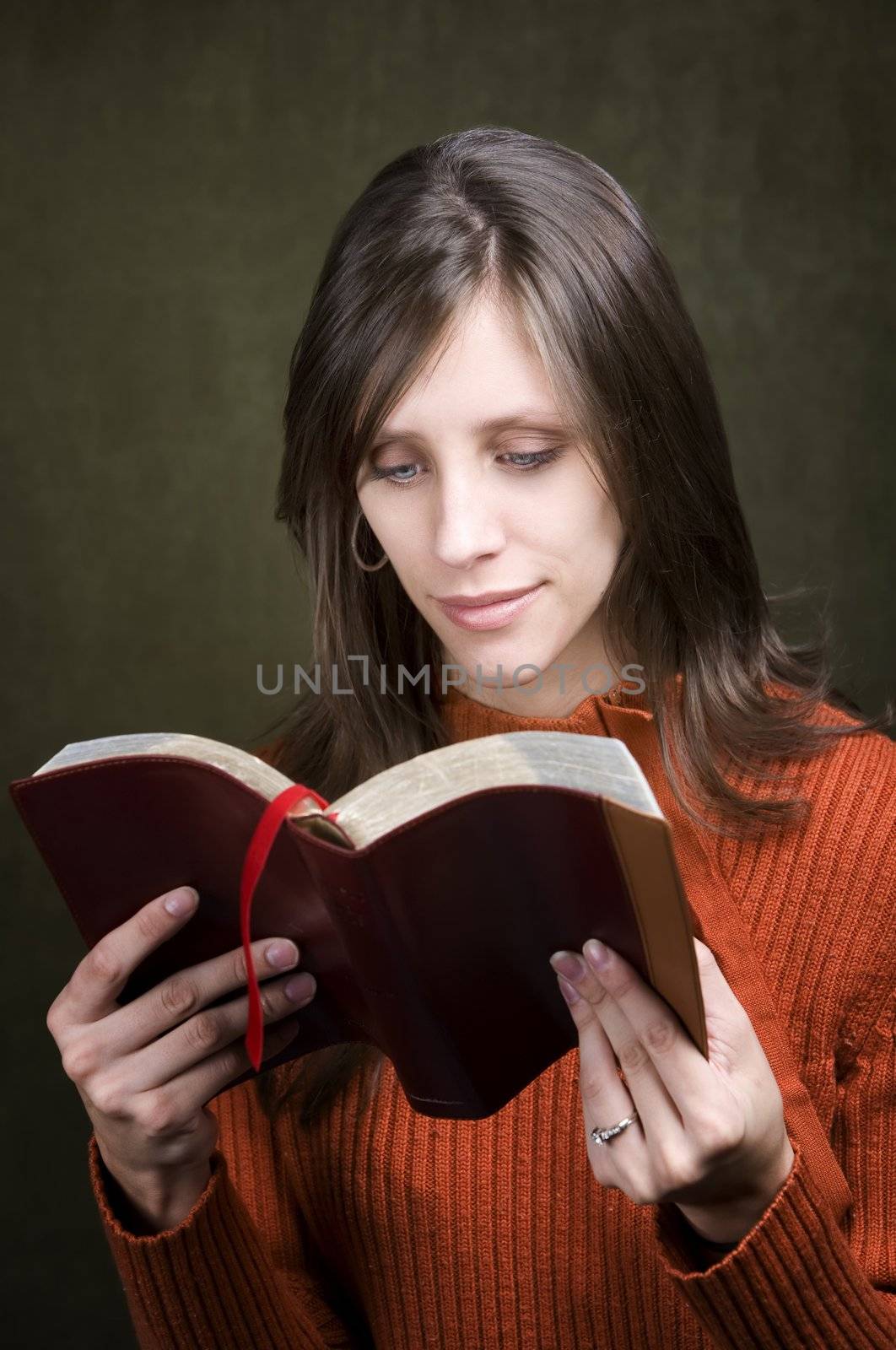 Pretty woman in orange sweater with Bible