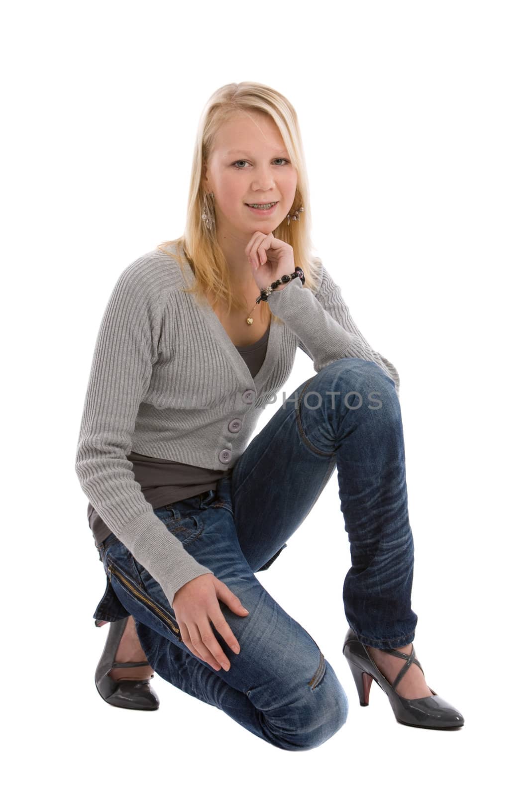 Cute blond teenage girl kneeling on white background