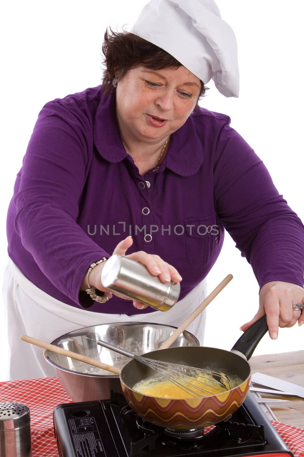 Female chef adding some salt to her mixture in the wok