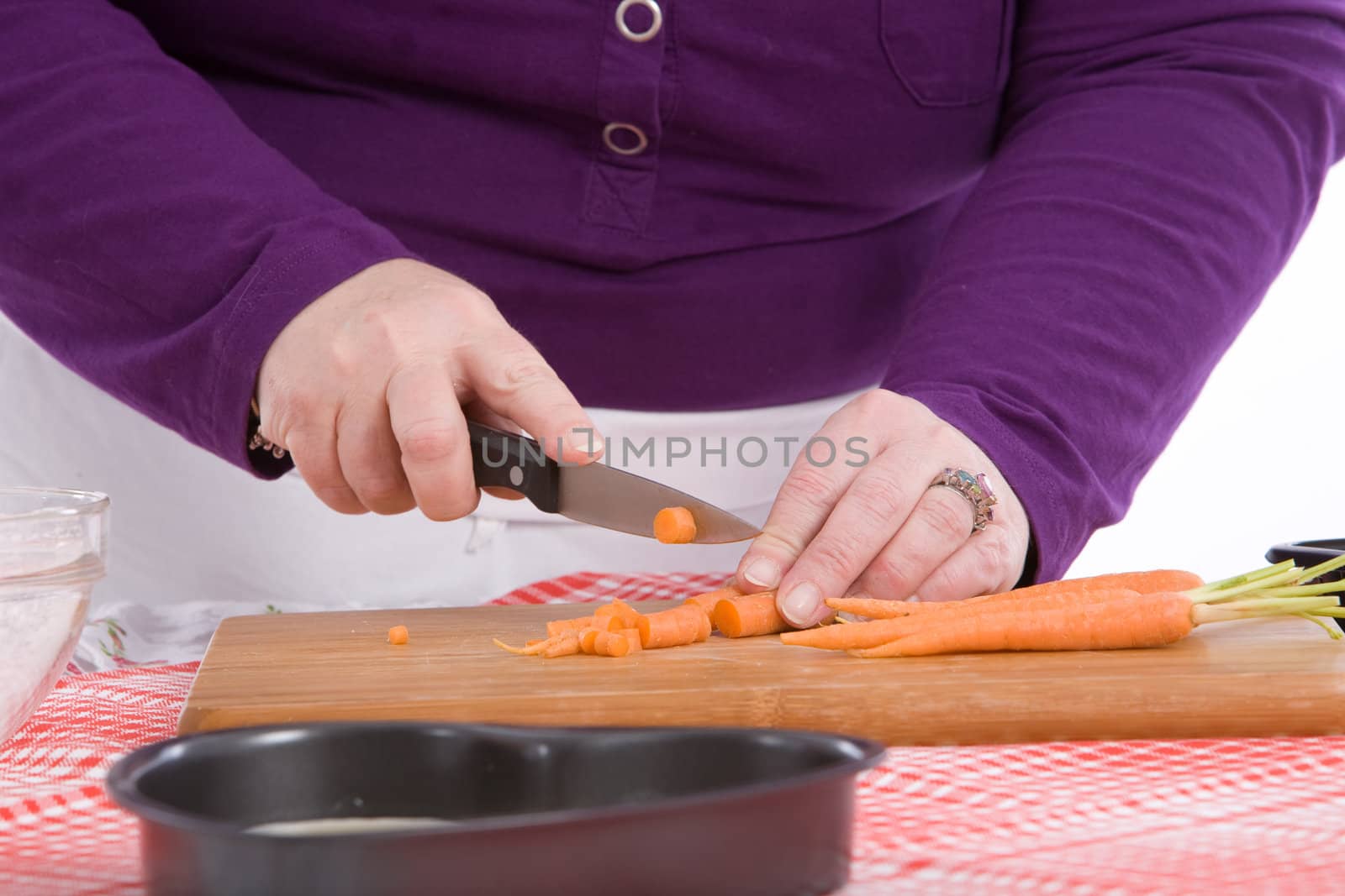 Chef preparing the carrots by chopping them on a board