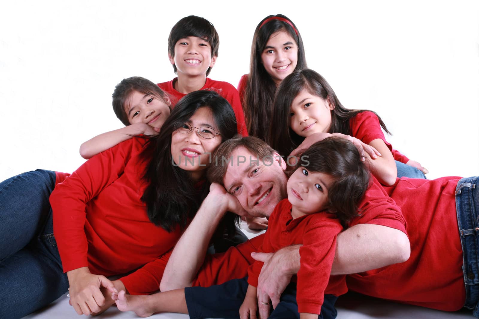 Large family of seven in red shirts and jeans isolated on white