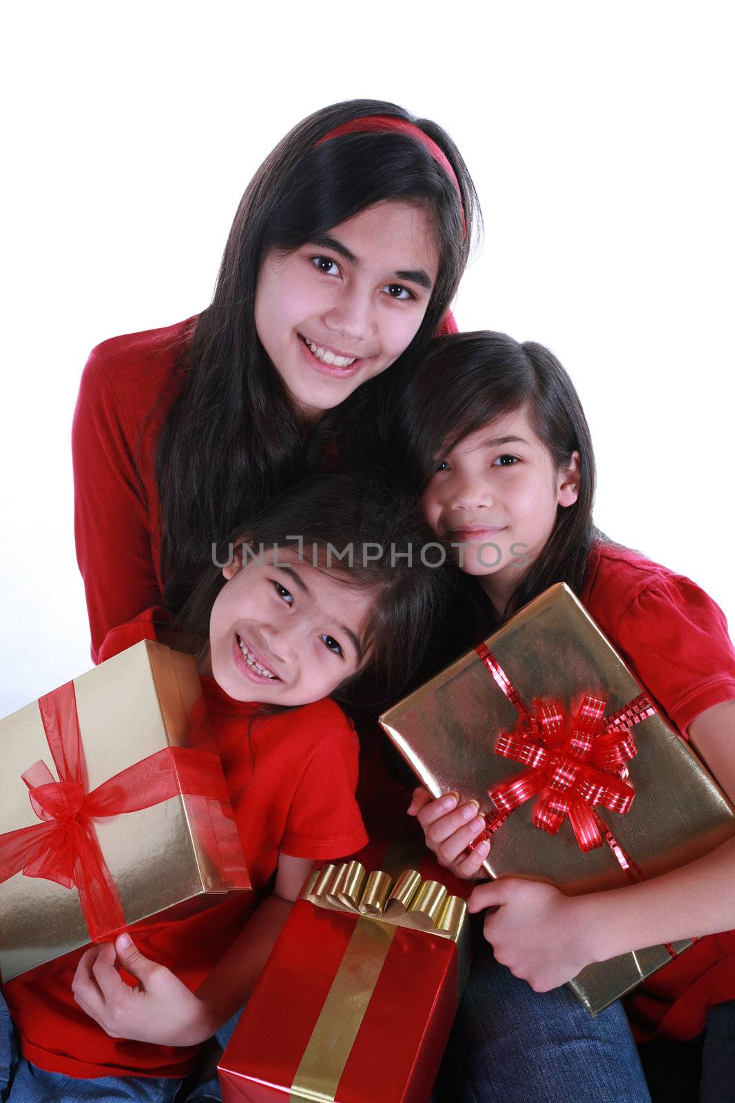 Three sisters wearing red shirts holding presents