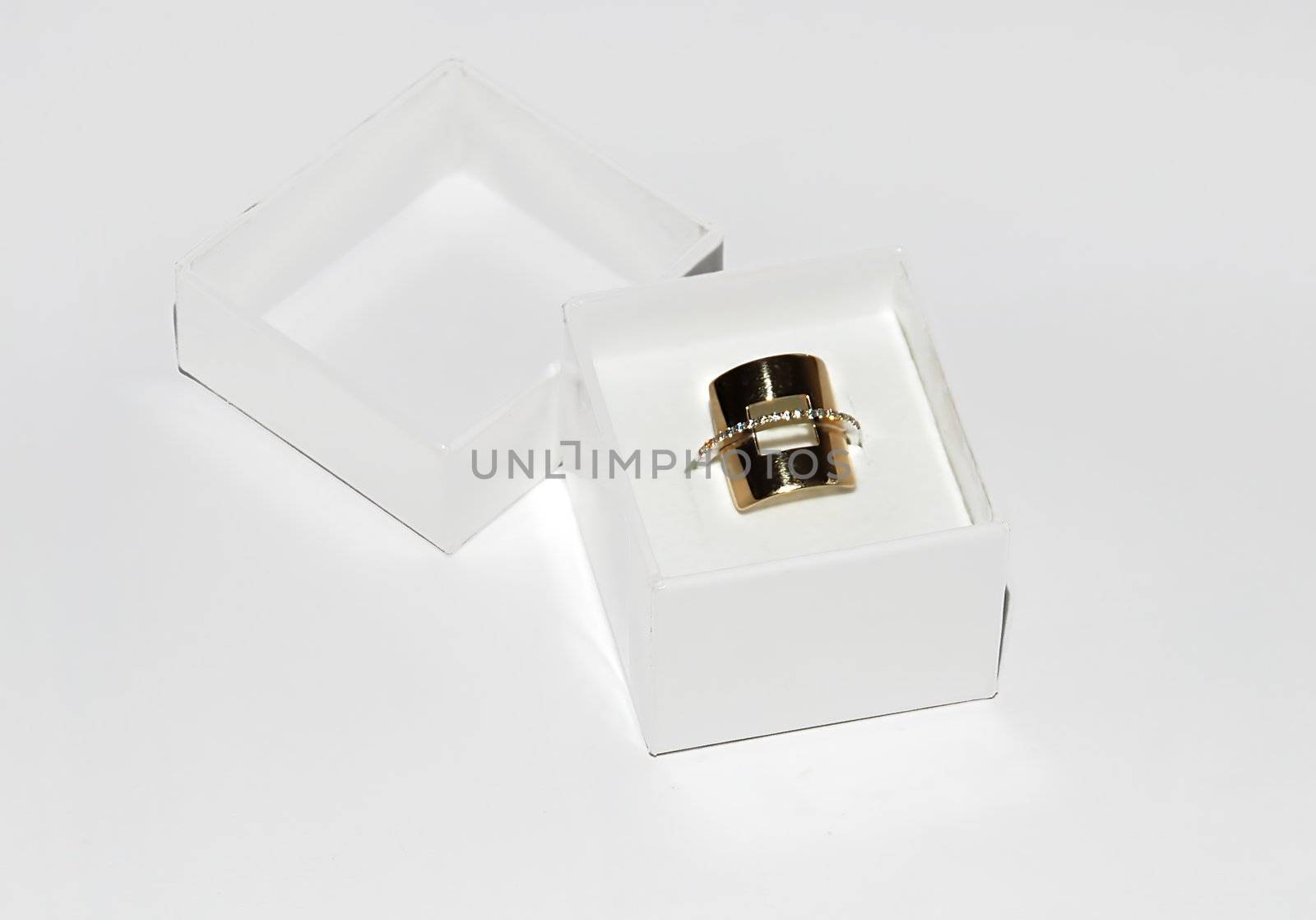 golden ring gift in paper box over white background