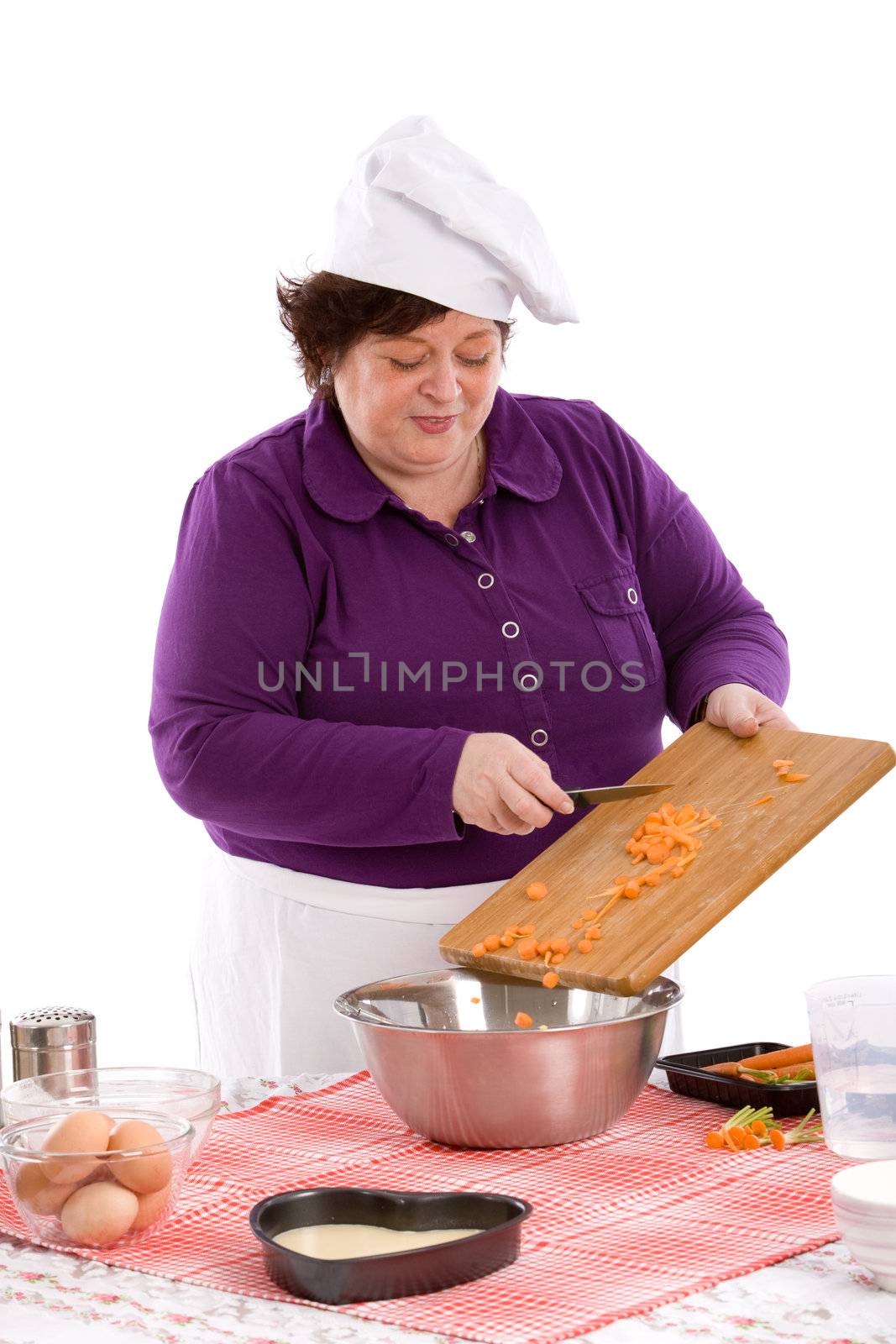 Female chef putting the carrots in the bowl