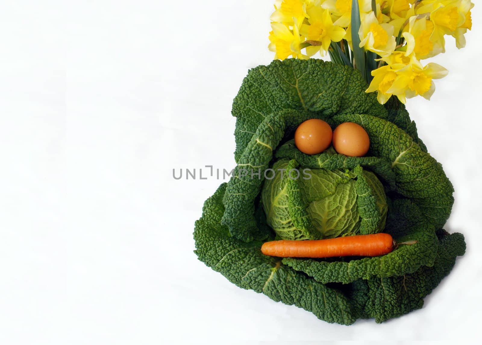 Head of cabbage over white with egg eyes and carrot mouth