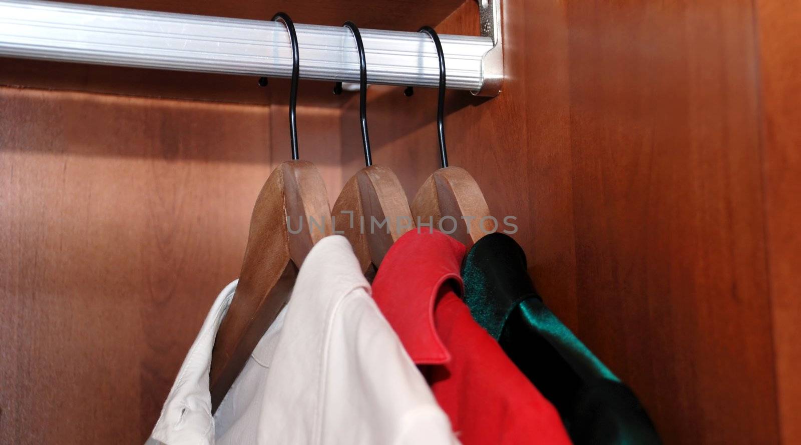 three clothes-hanger with chemises in wooden wardrobe