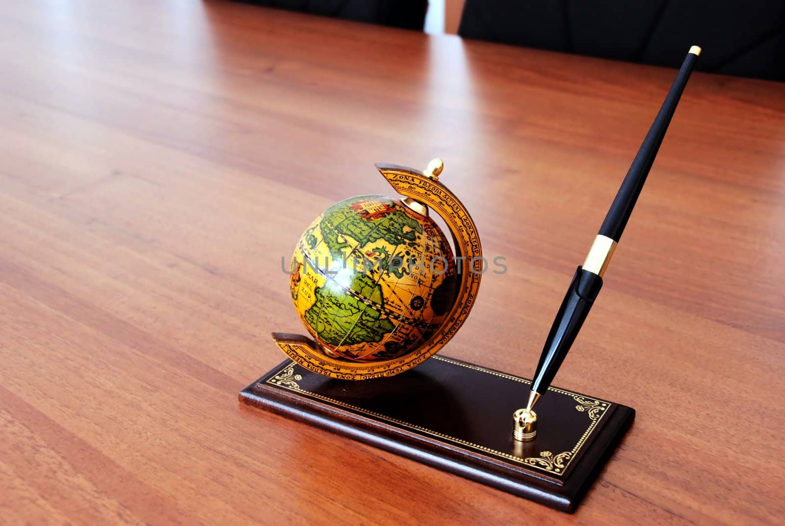 globe and pen on prop over brown office desk