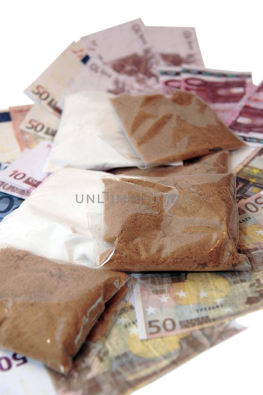 a stash of drugs and money showing a high cost to life against a white background