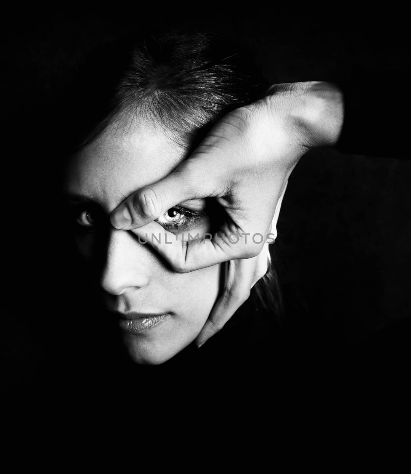 Model wearing dark makeup with hand in front of her eye