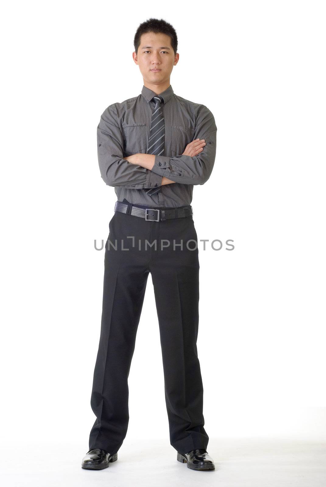 Confident young business man standing and looking, full length portrait on white.