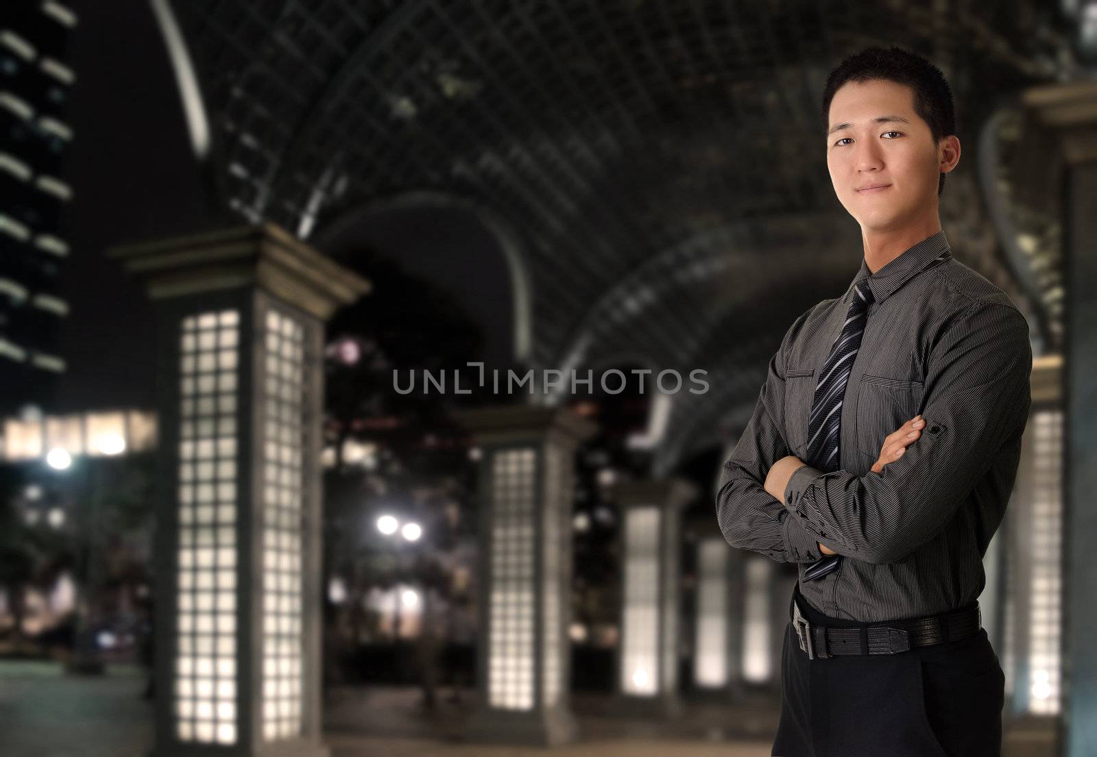 Portrait of young business man in night of city.