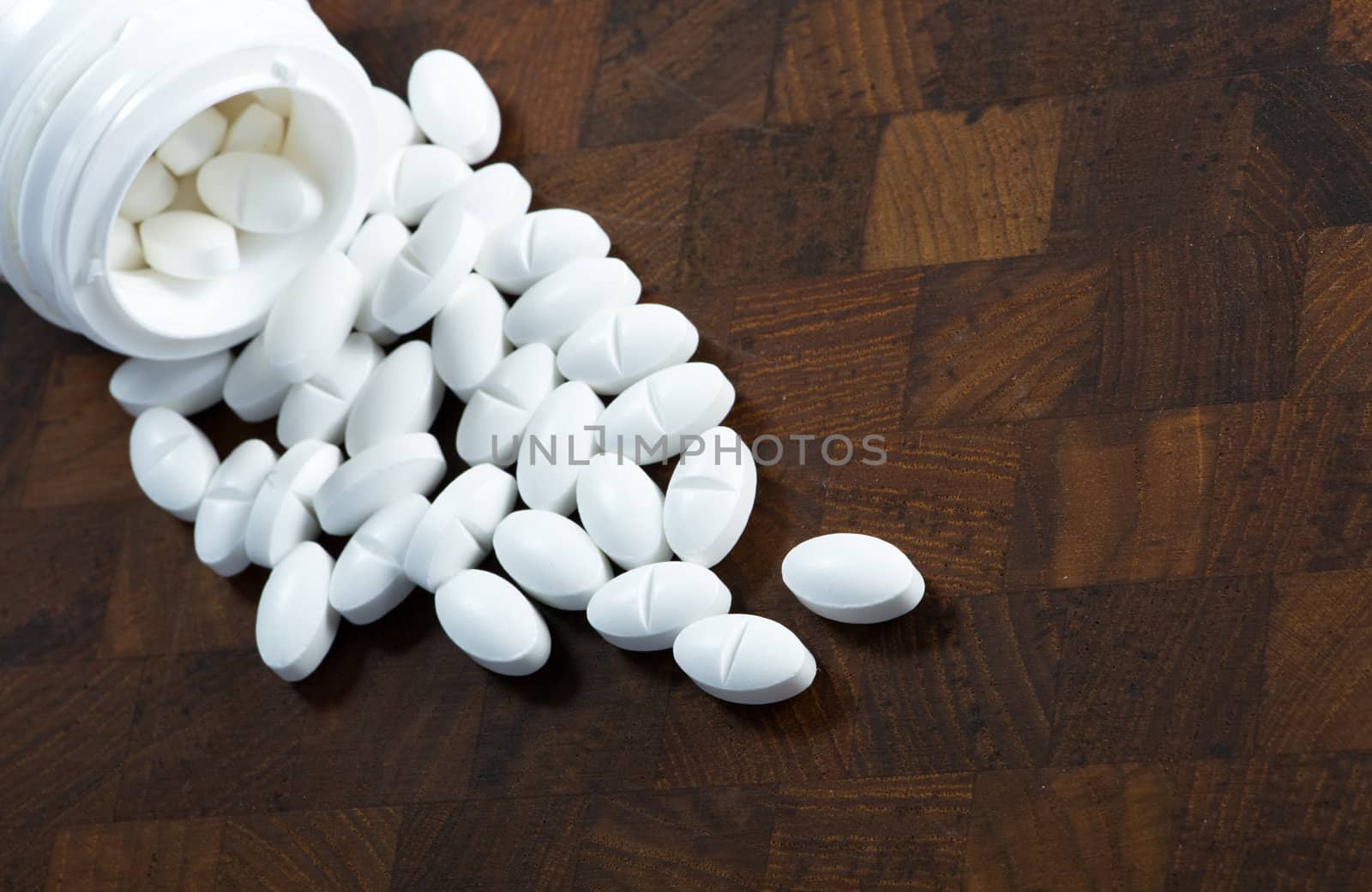 Glass of pills on wood background by fljac