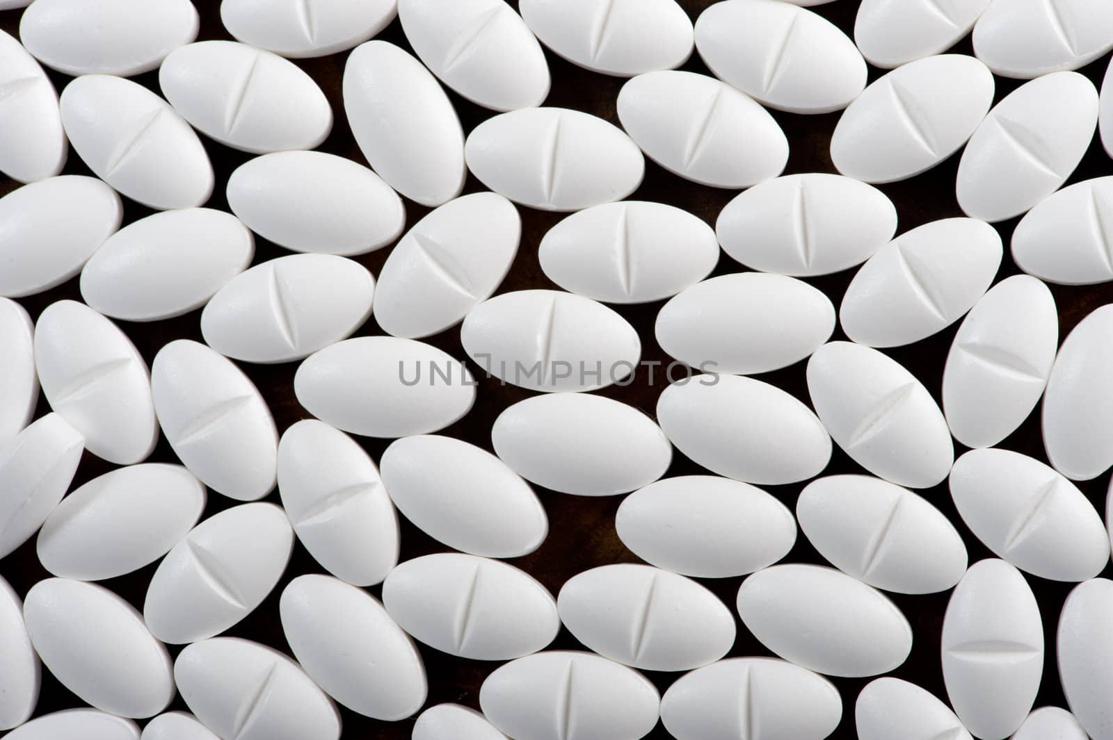 White pills seen on dark background by fljac