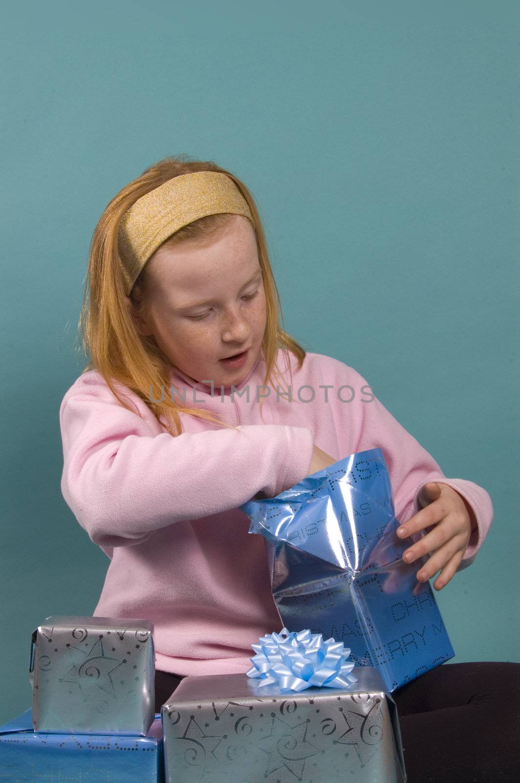 little red girl is opening her christmas presents