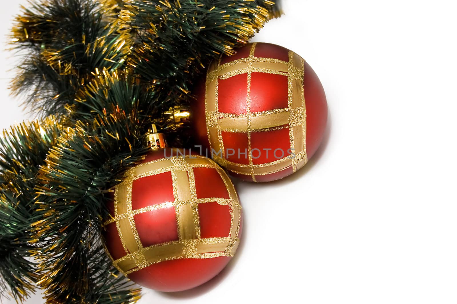Red balls and green Christmas decoration isolated over white