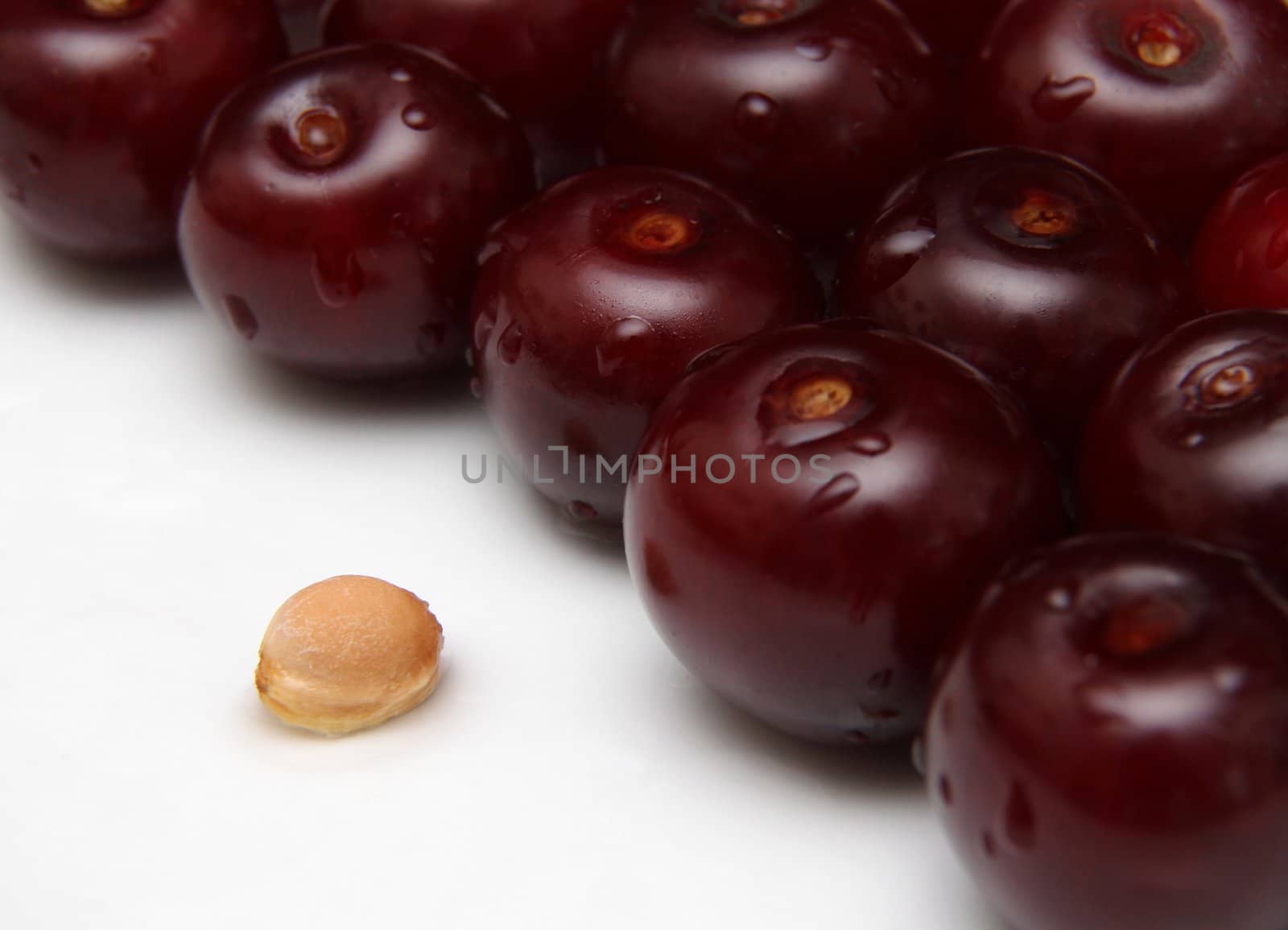 A group of cherries and a cherry seed.