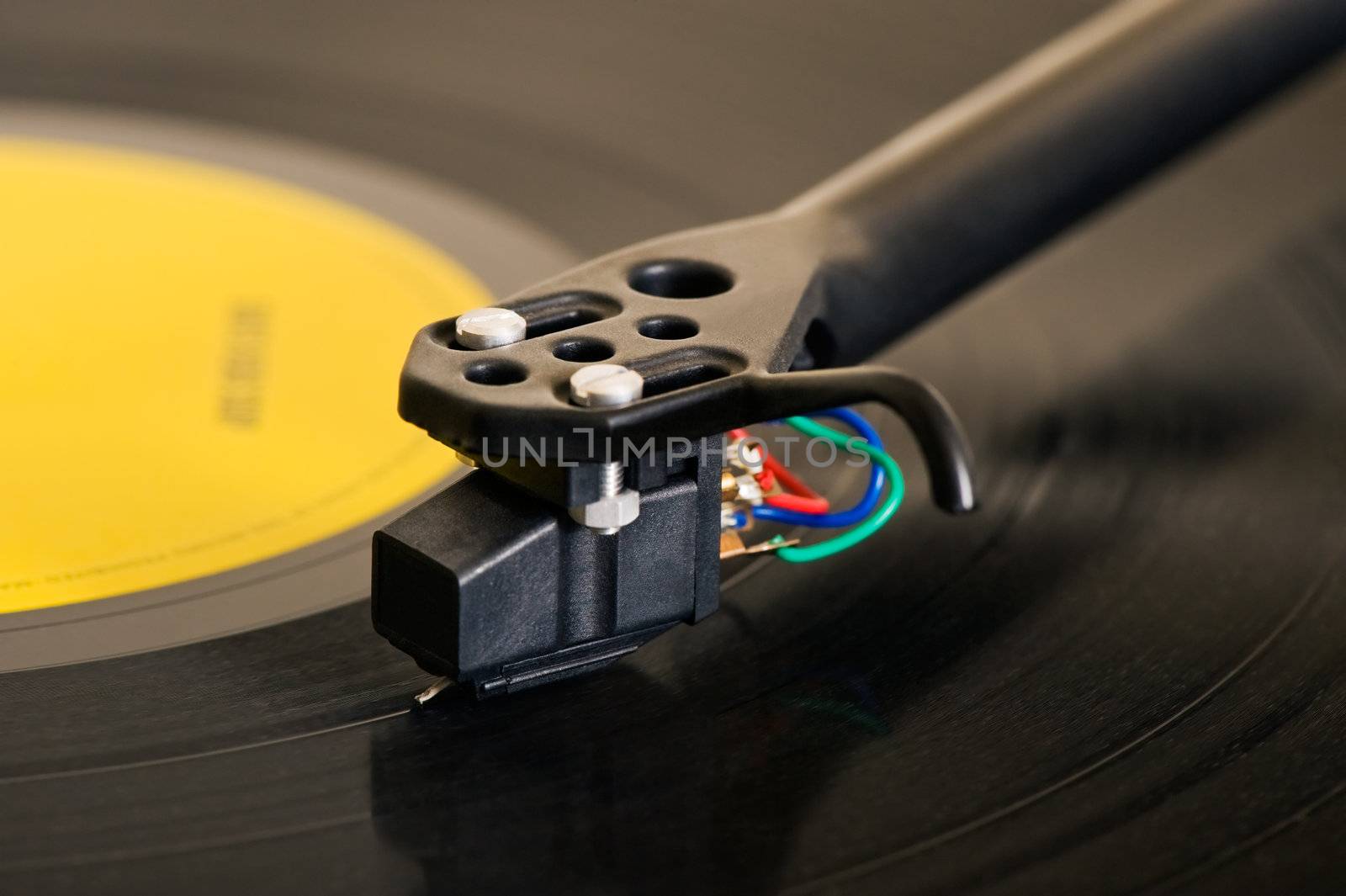 Close-up image of a turntable showing details of the cartridge and tonearm