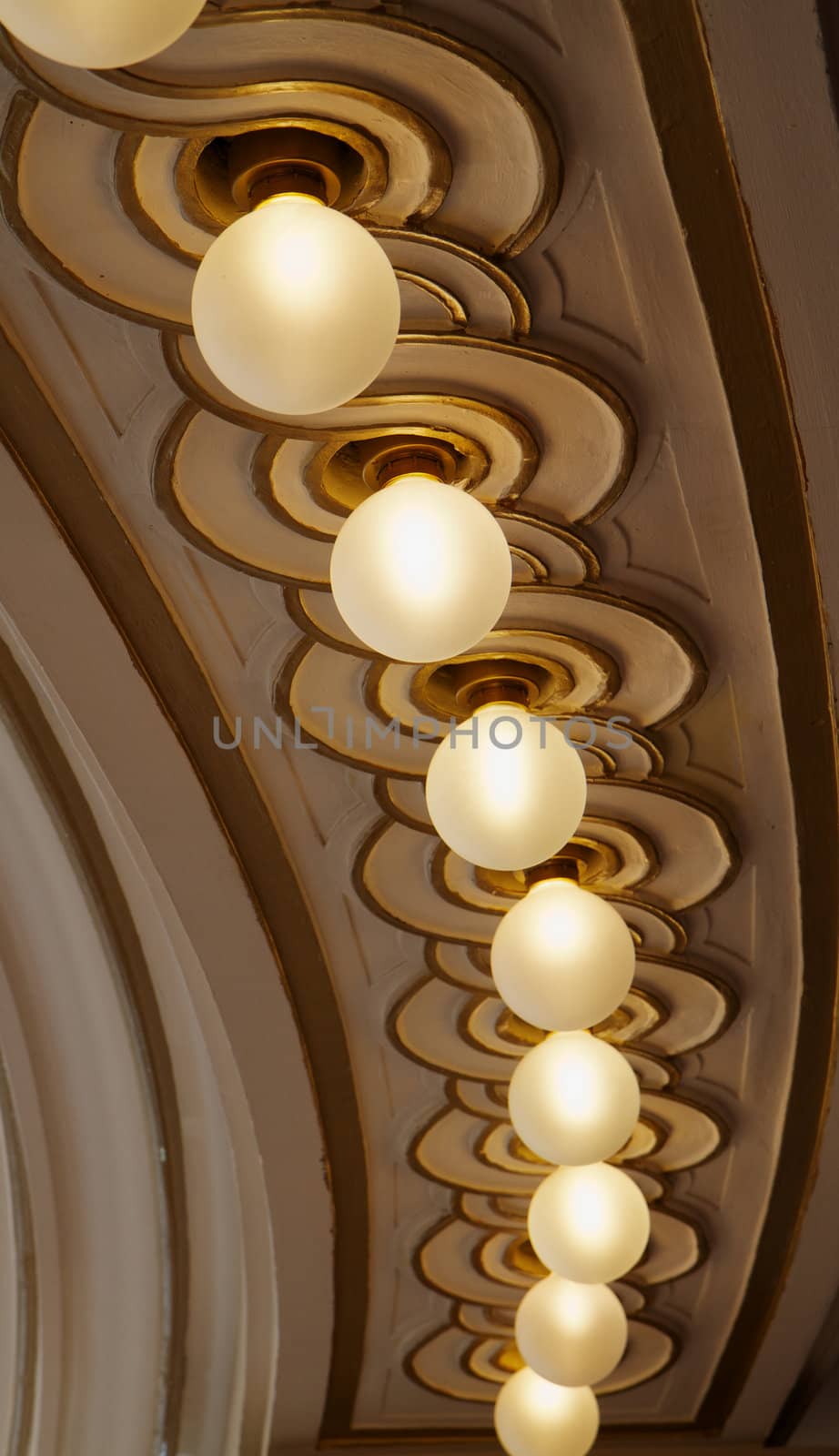 Curved row of ornate ceiling lights with gold trim