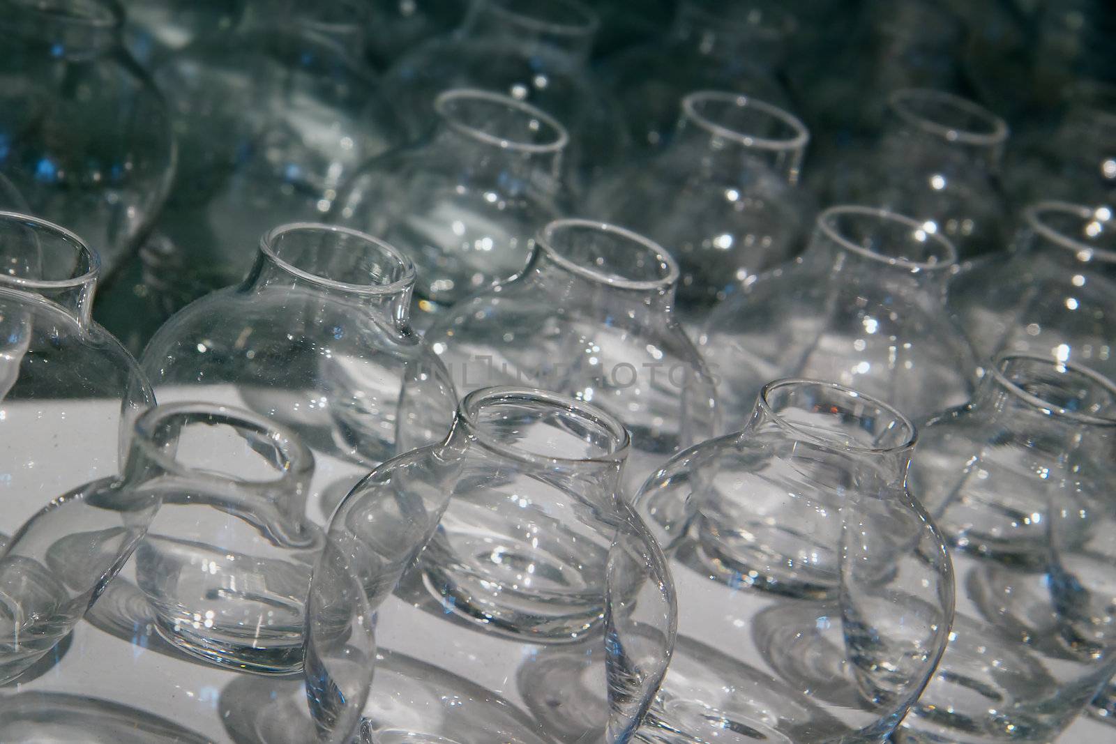 Rows of empty flower vase shaped glass containers
