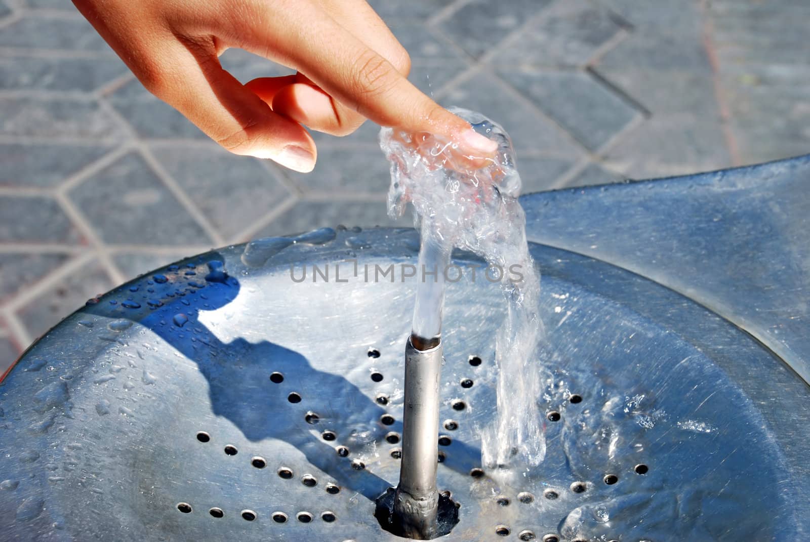 Water drinking fountain with human hand close up