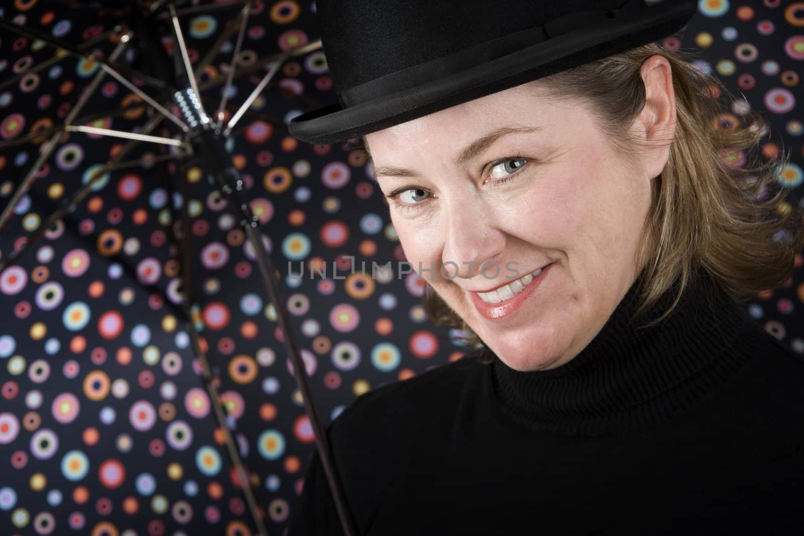 Woman in bowler hat with spotted umbrella