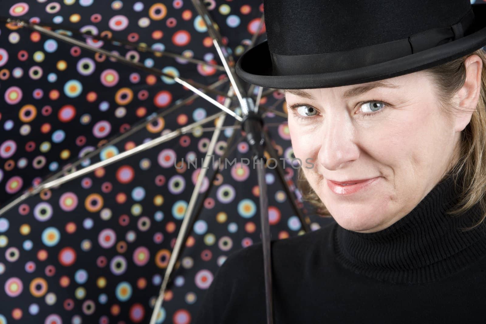 Woman in bowler hat with spotted umbrella