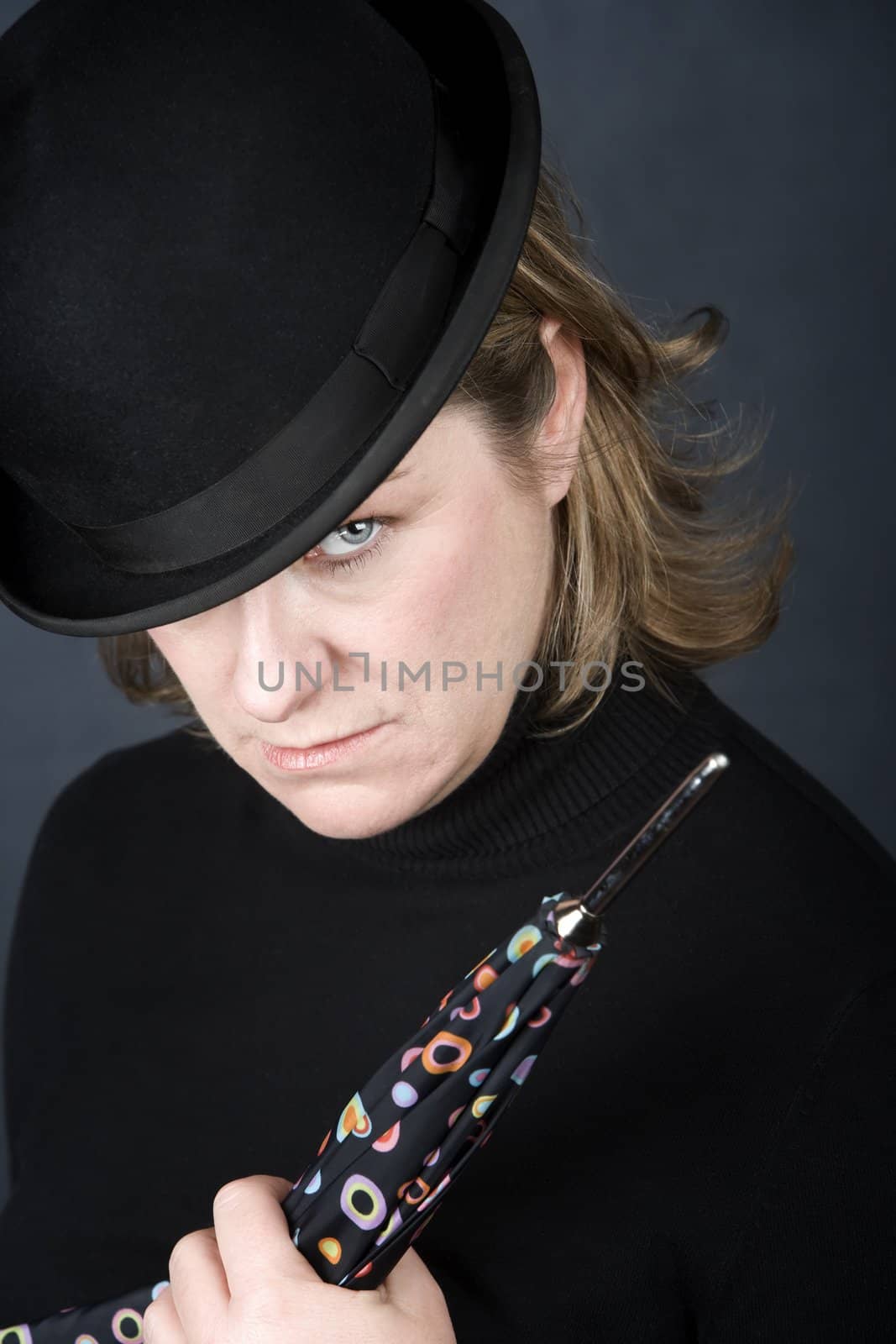 Woman in bowler hat with spotted umbrella