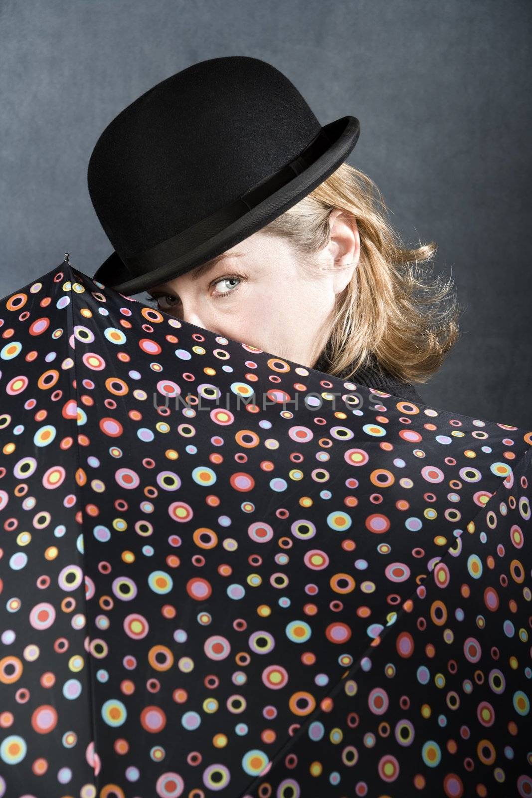 Woman in bowler hat with spotted umbrella