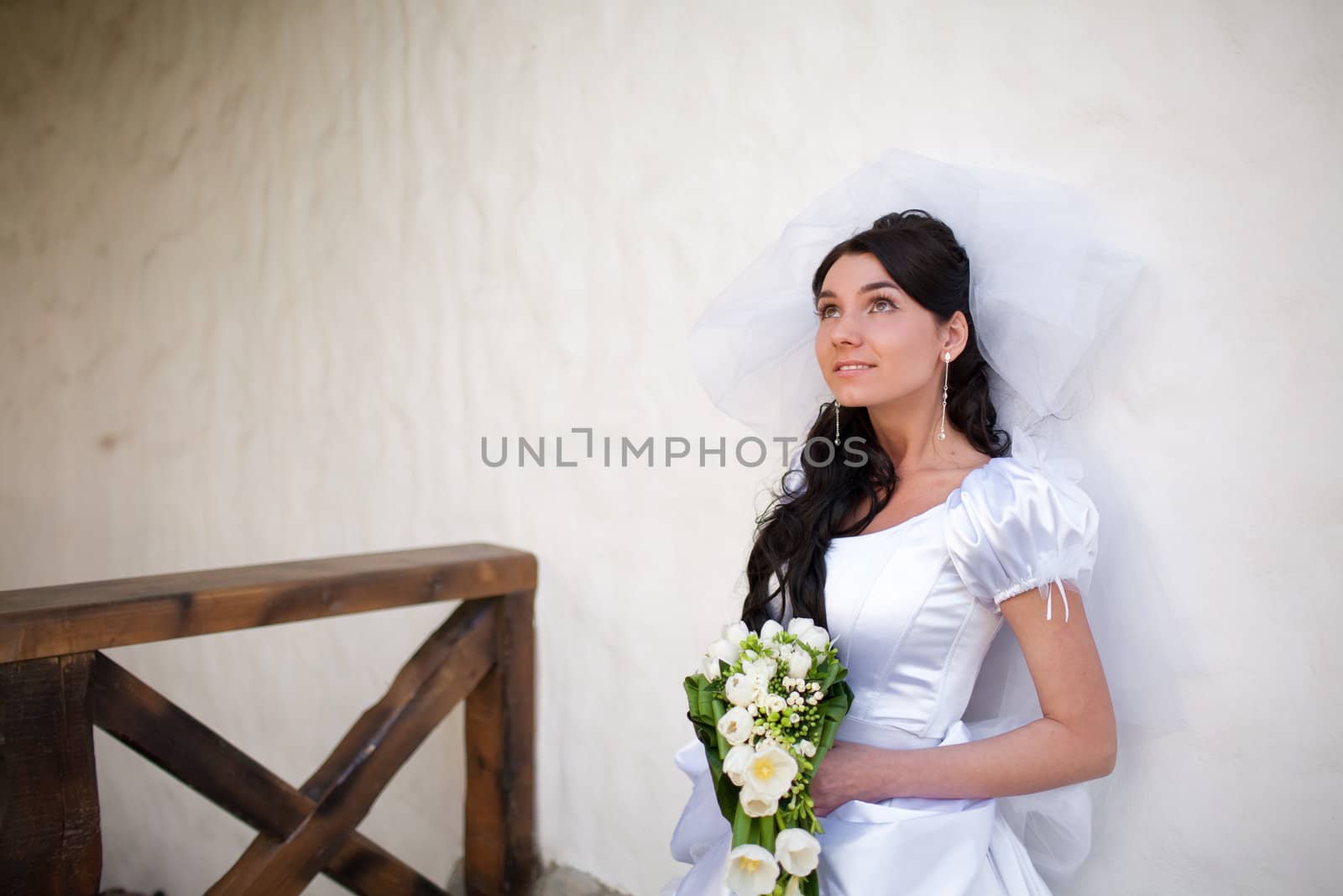 bride by the white wall looking up