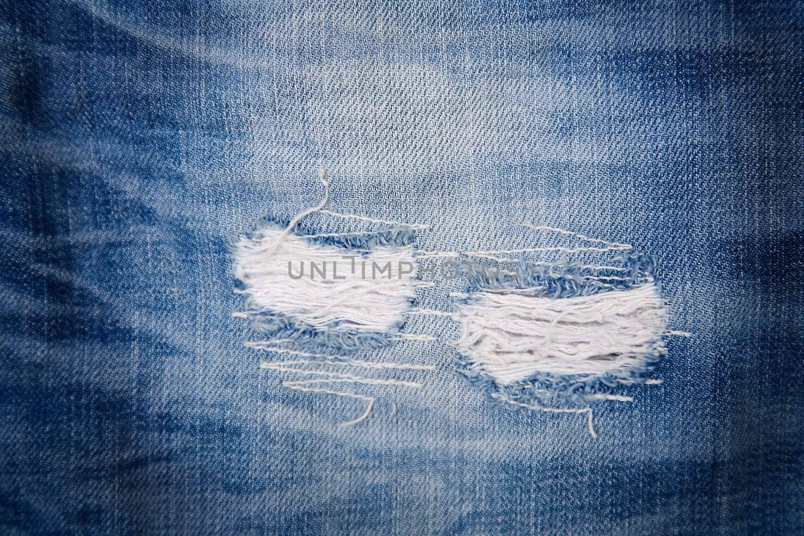 detail of torn blue denim, front view