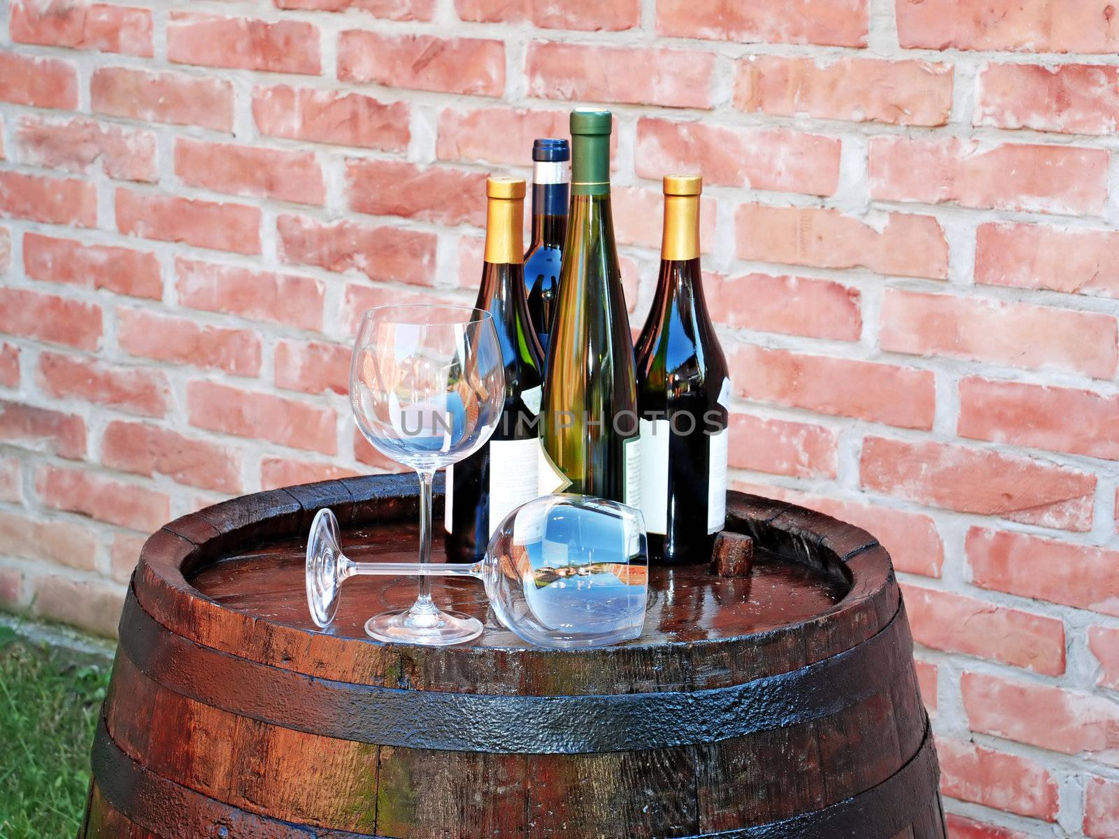 glasses and bottles of wine over wooden barrel