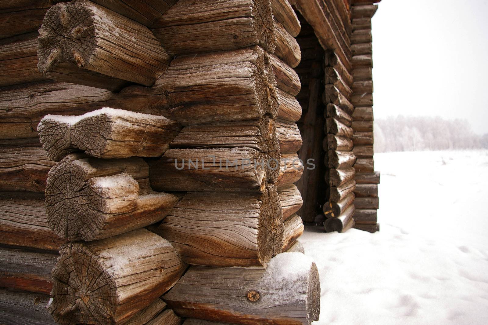 Corner of Timbered log hut. Winter and snow