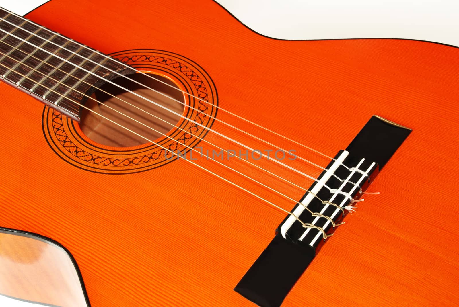 wooden orange acoustical guitar fragment over white