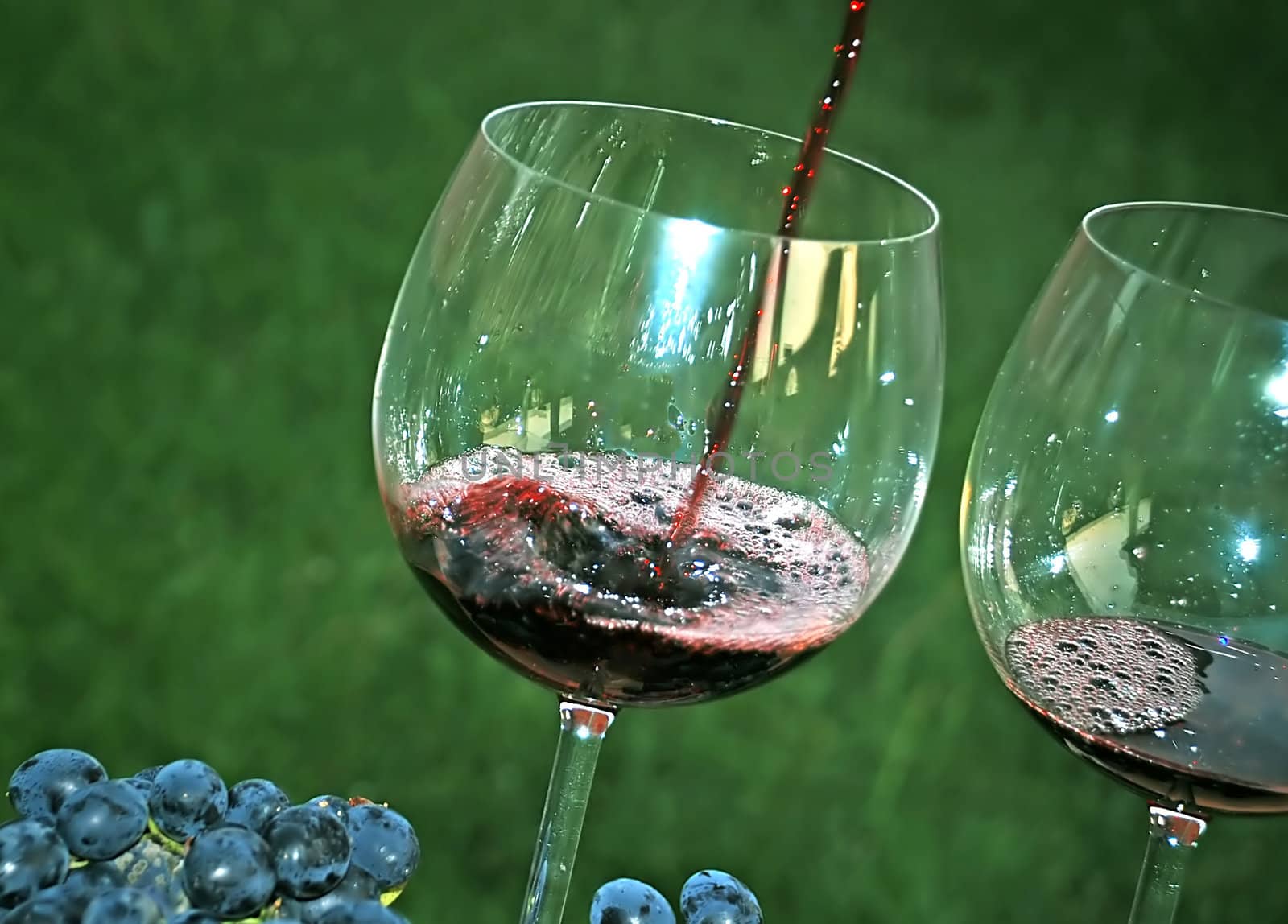 pouring red wine in glass by simply