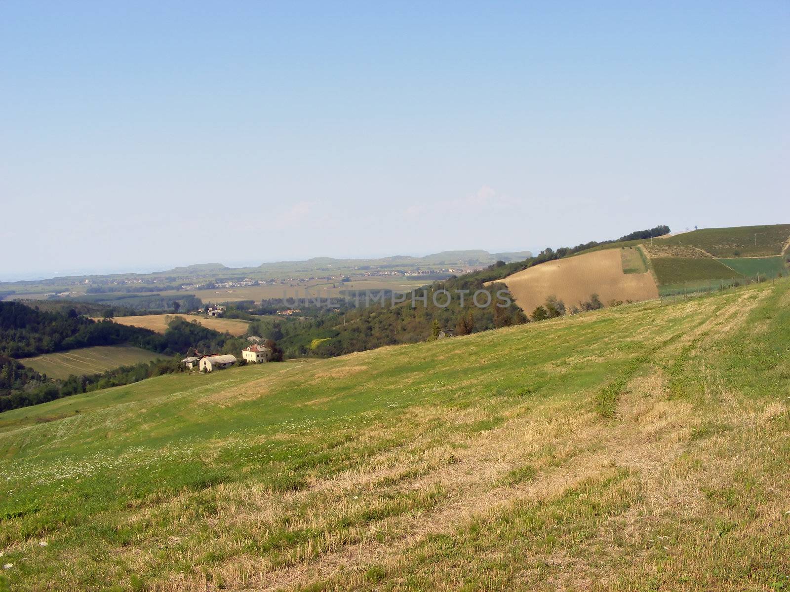 Landscape of hills and fields under a blue sky