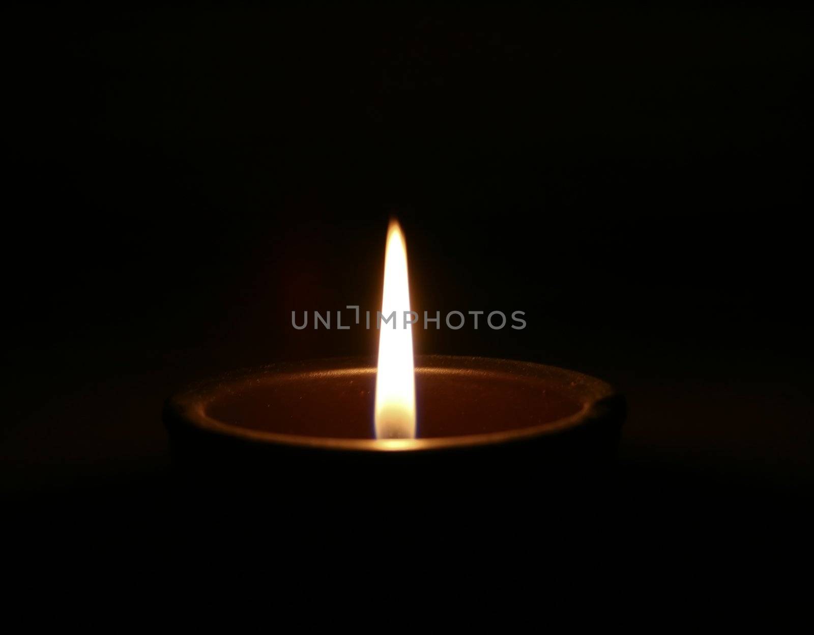 A solitary candle in the middle of darkness