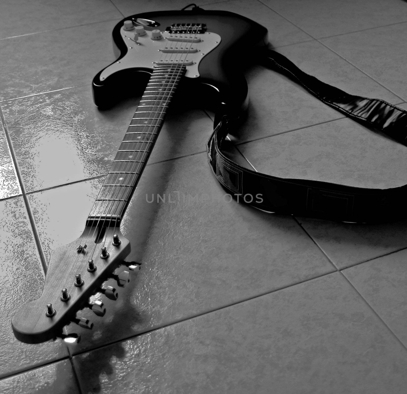 An electric guitar on the floor, black and white