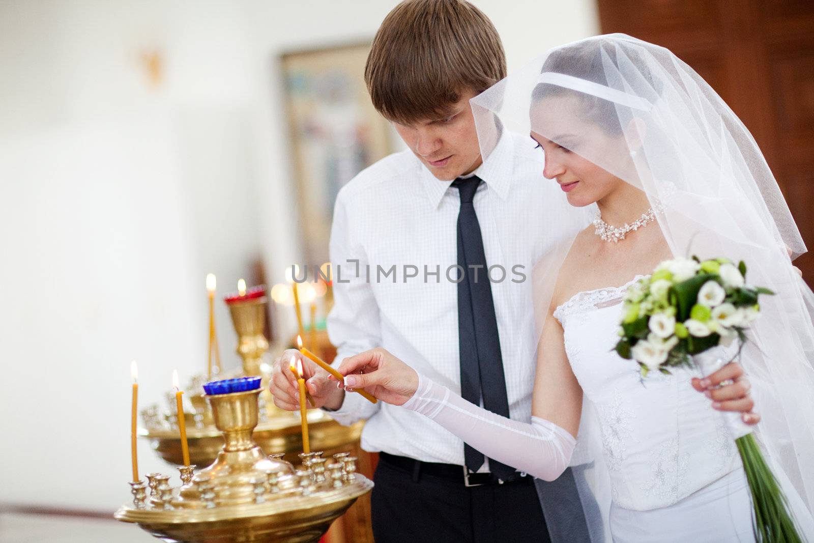 couple lighting candles in a church