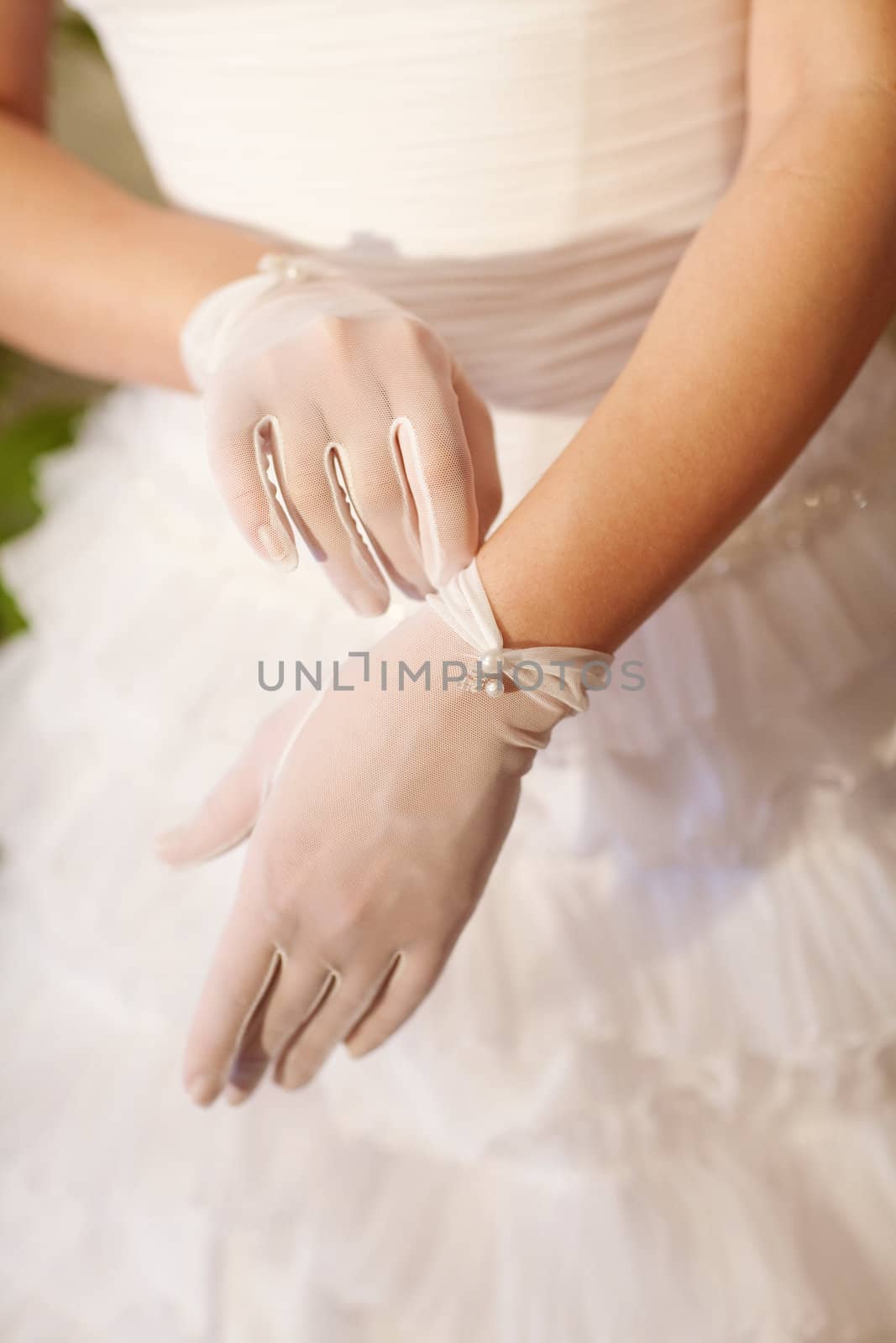 beautiful bride puts on a white glove
