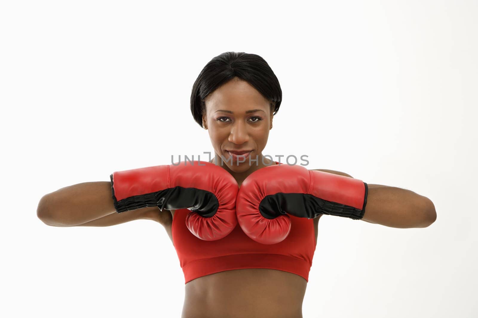 African American young adult woman wearing boxing goves with fists together.