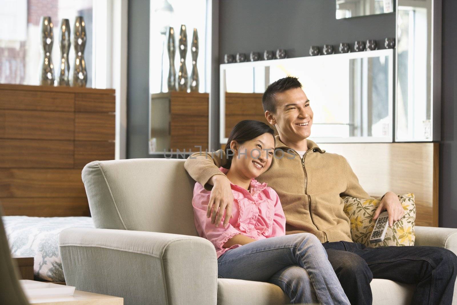 Asian couple watching television.
