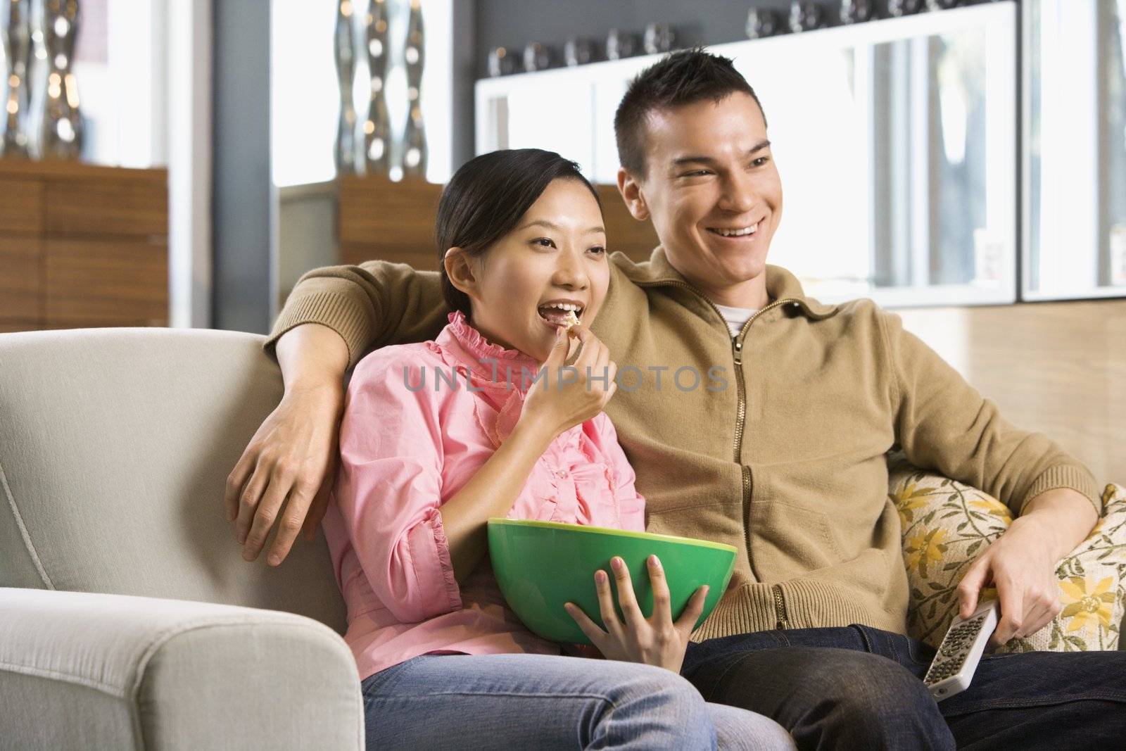 Asian couple watching television.