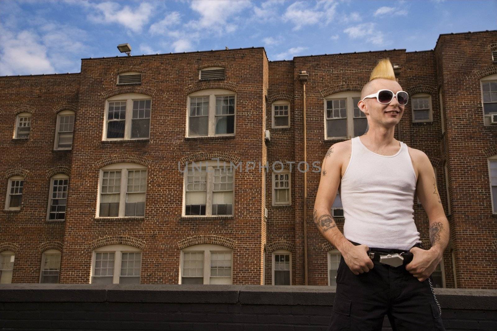 Portrait of a mid-adult Caucasian male punk outside with building in background.