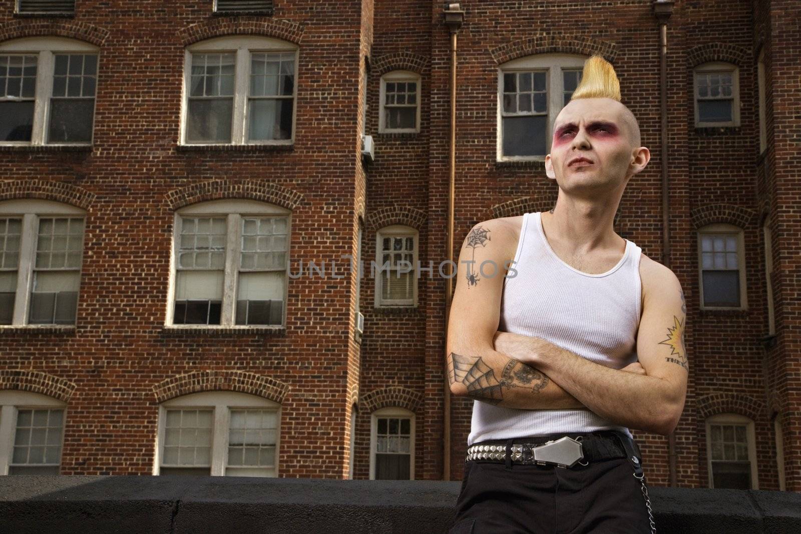 Portrait of a mid-adult Caucasian male punk with building in background.