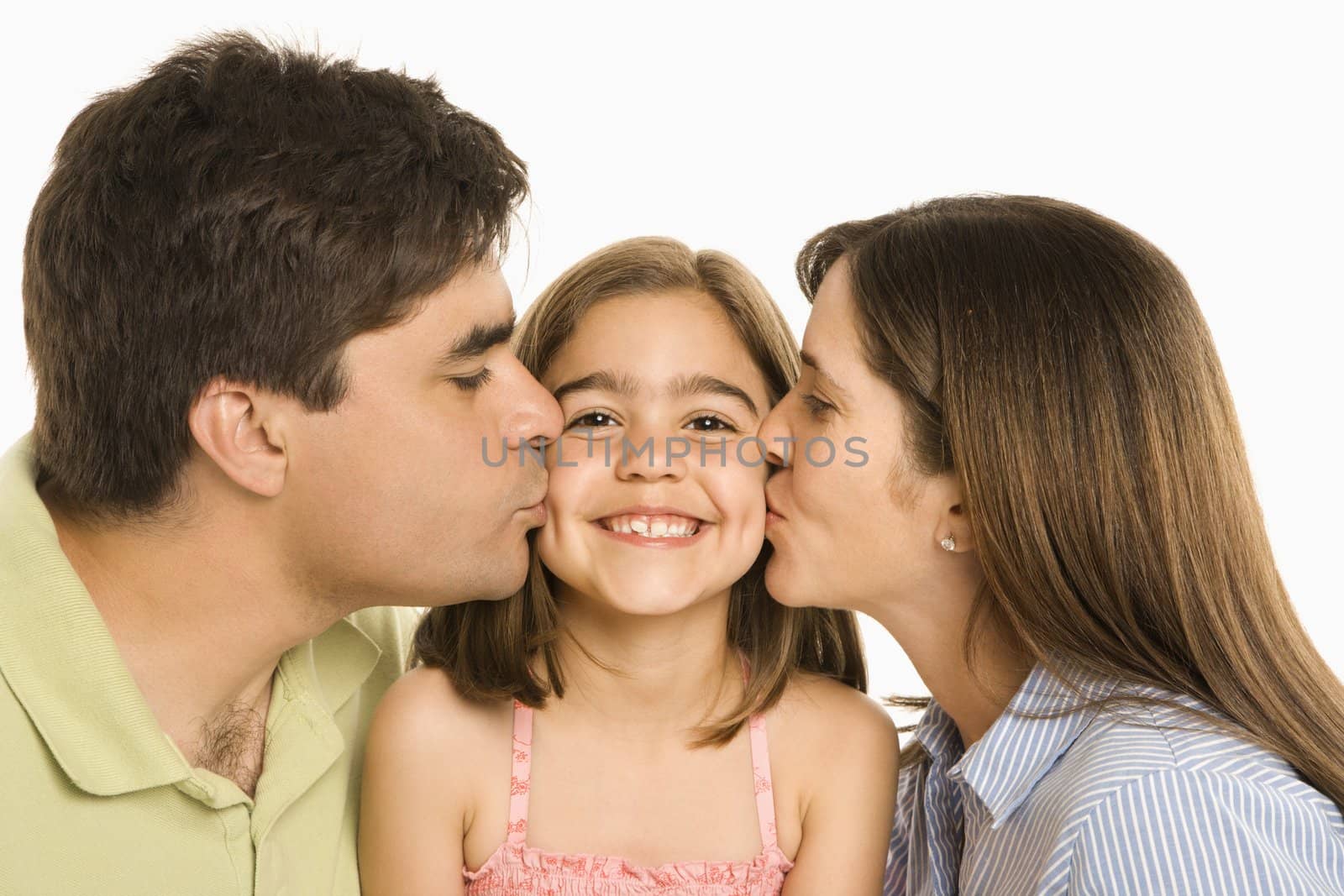 Mother and father kissing smiling daughter on cheek.