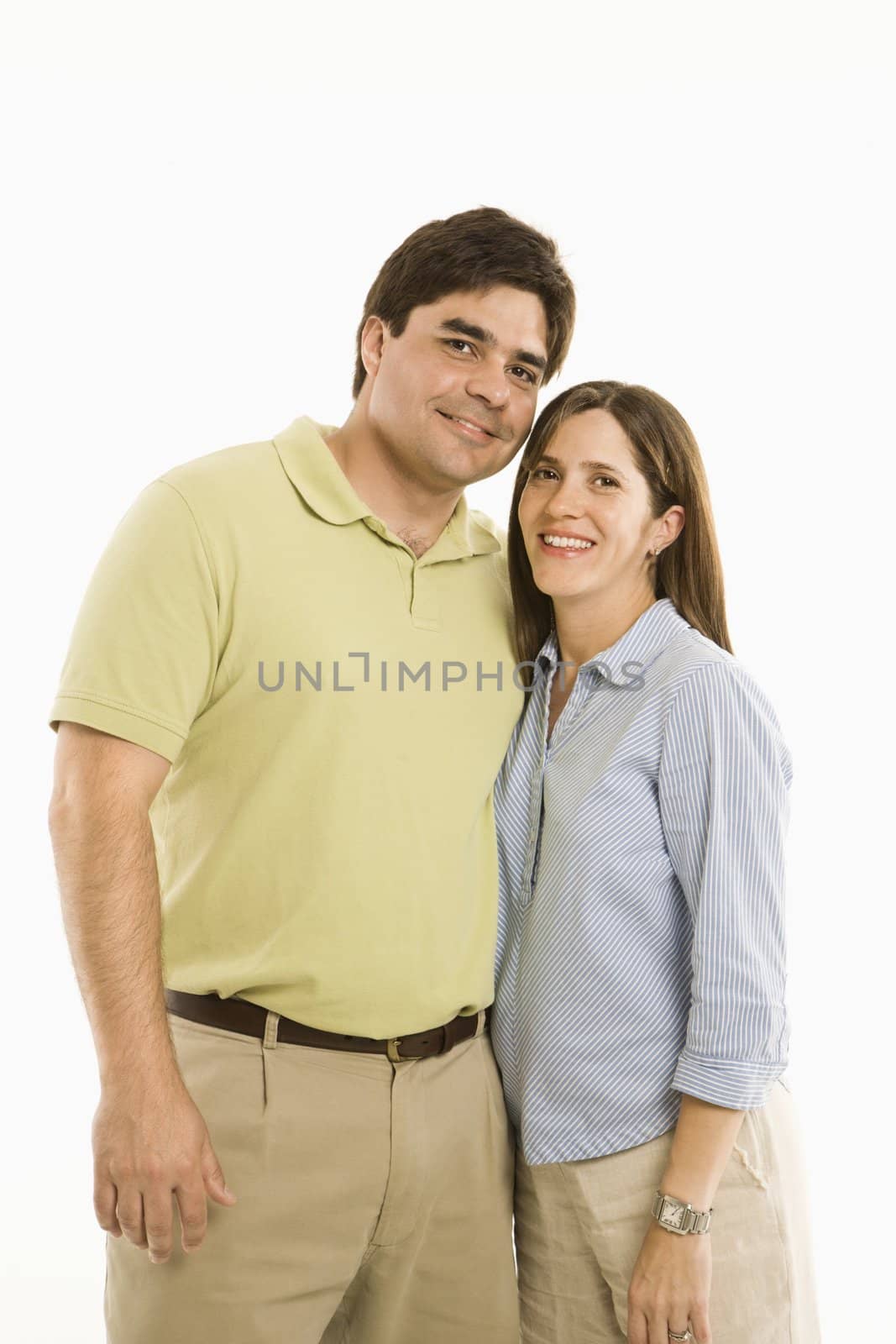 Portrait of smiling couple standing against white background.