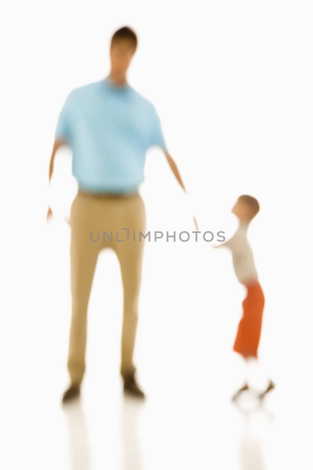 Soft focus father holding son's hand.