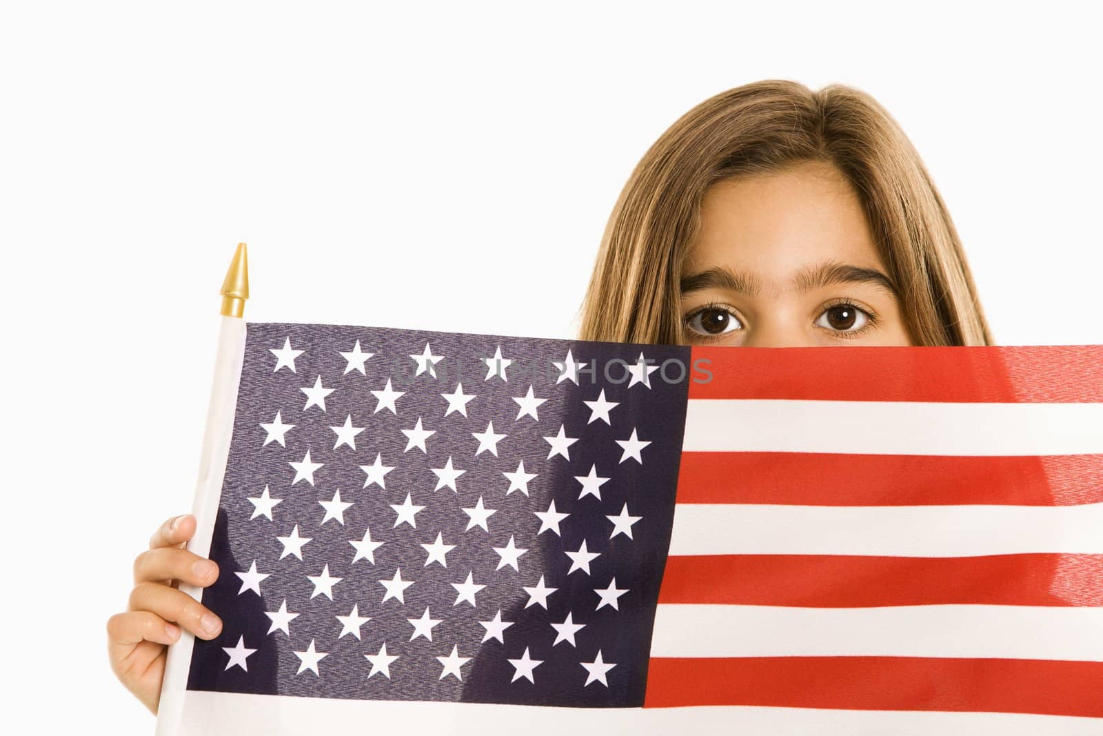 Girl peeking over American flag against white background.