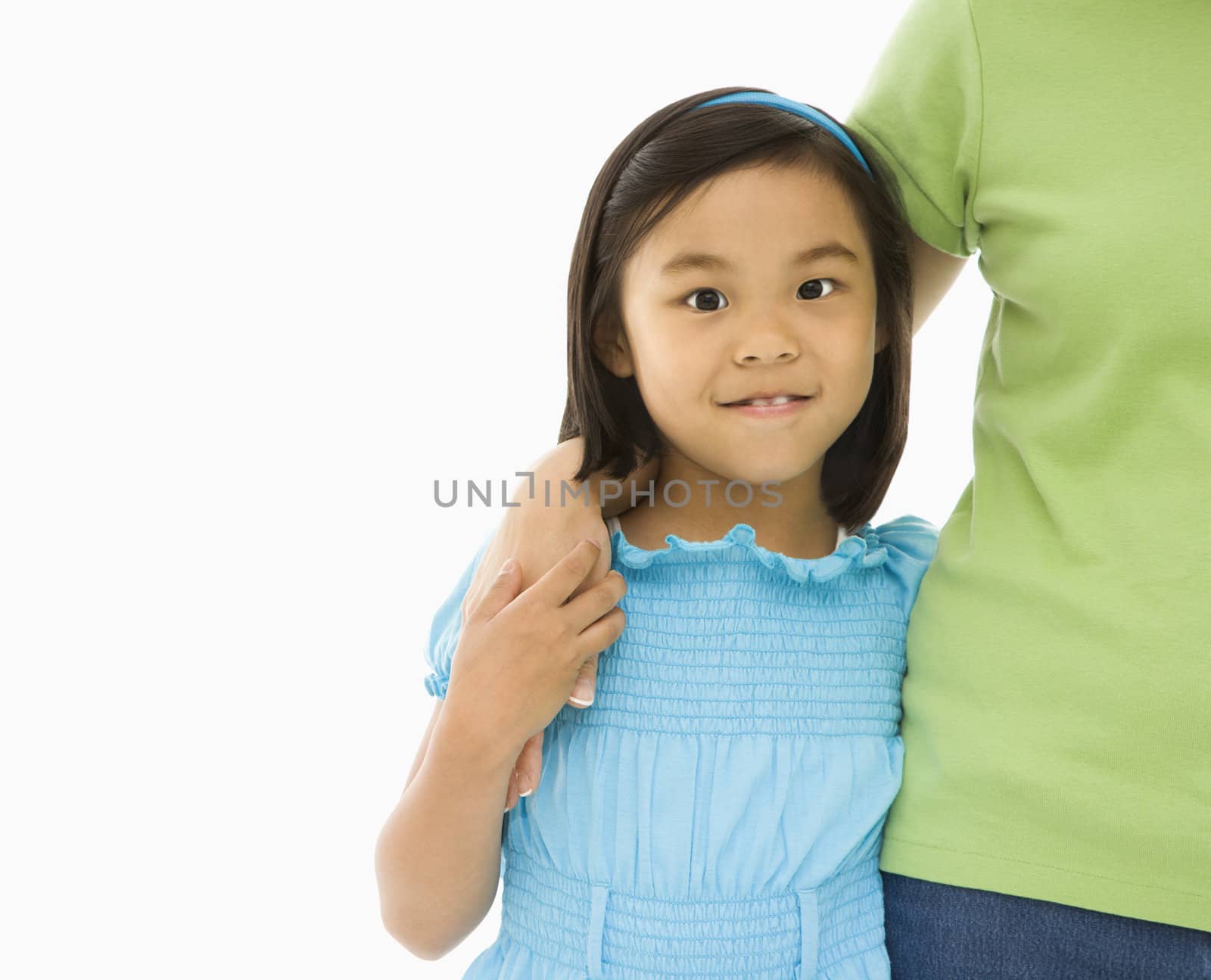 Asian mother and daughter standing with arms around eachother.