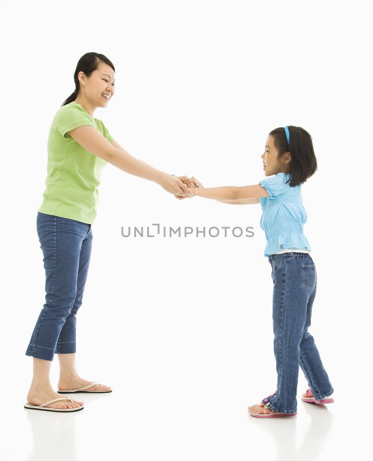 Asian mother and daughter playing together holding hands.